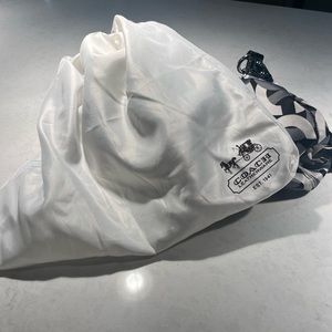 Coach handle bag. Black and white, purple interior.